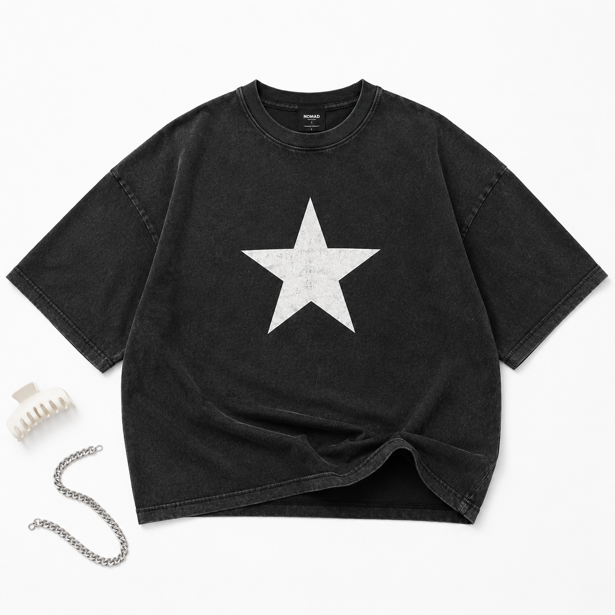 Model wearing Stellar Star oversized washed black t-shirt with distressed white star graphic on outdoor crosswalk flat